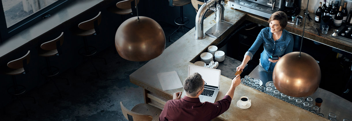 Customer handing credit card to barista
